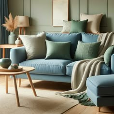 a living room with blue couches and pillows on top of the couch, next to a coffee table