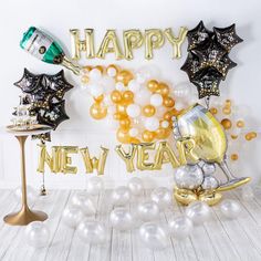 new year balloons and decorations in gold, silver and white colors on a wooden floor