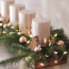 candles are lined up on a table with christmas decorations