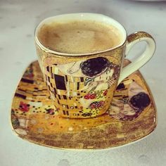 a coffee cup on a saucer with an artistic painting