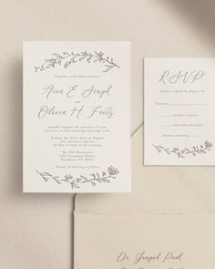 the wedding stationery is laid out on top of an envelope and in front of it