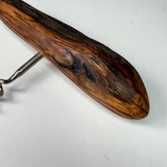 a piece of wood that is attached to a wrench on a white table top