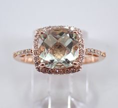 14K Rose Gold Diamond and Green Amethyst Halo Engagement Ring. This ring is set with one genuine Cushion Cut Green Amethyst (Prasiolite) in the center and forty natural Round Brilliant Diamonds. These diamonds are H color, SI1 clarity and weigh a total of .25 carat. The Green Amethyst is a pale green color, measures 8 X 8 mm and weighs 2 carats. This ring is 14KT Rose Gold, weighs 3.0 grams and is a finger size 7, which is resizable free of charge (please inquire about sizing with the finger size you need). The ring will be accompanied by an appraisal by a GIA Certified Diamond Grader with the retail replacement value of $1,465.00. I will ship this ring promptly in a gift box. Elegant Green Amethyst Ring For Formal Occasions, Elegant Amethyst Wedding Ring With Vs Clarity, Elegant Cushion Cut Gemstones For Wedding, Green Amethyst Wedding Rings With Gemstone Accents, Elegant Green Amethyst Ring With Accent Stones, Green Amethyst Rings With Gemstone Accents For Wedding, Elegant Green Amethyst Ring As A Gift, Elegant Green Amethyst Ring For Anniversary, Elegant Green Amethyst Ring For Wedding