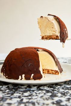 a piece of cake with ice cream on it being lifted from the plate by a fork