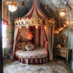 a bedroom with a canopy bed in the middle of it and lights hanging from the ceiling