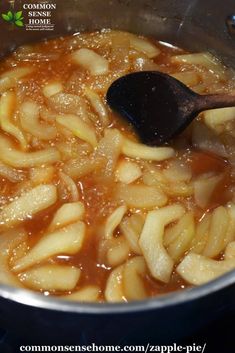 the food is being cooked in the pot on the stove with a wooden ladle