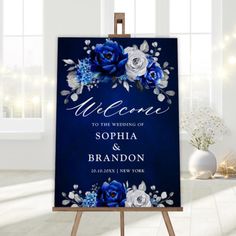 a blue and white wedding welcome sign on an easel