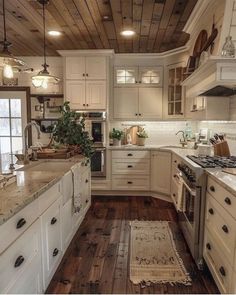 a kitchen with white cabinets and wood floors is pictured in this image, there are lights hanging from the ceiling