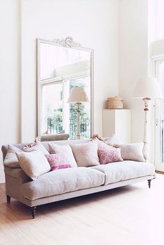 a living room filled with furniture and a large mirror