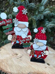 two christmas gnomes sitting on top of a tree stump