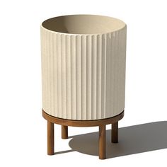 a white planter sitting on top of a wooden stand next to a white wall