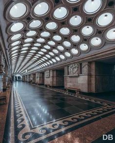 the ceiling is covered with round windows and circular lights in an empty room, along with marble flooring