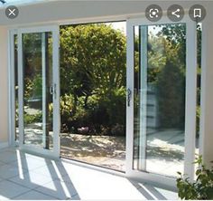 an empty room with sliding glass doors leading to the outside patio and trees in the background