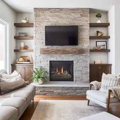 a living room with a fire place, couches and a flat screen tv on the wall