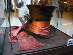 a hat and scarf on display in a glass case