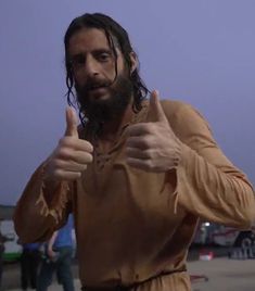 a man with dreadlocks giving the thumbs up