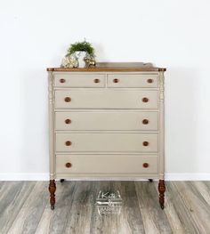 an old dresser is painted white with wood handles and knobs on the bottom drawer