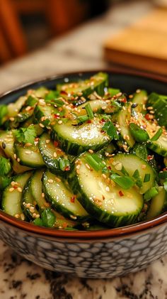 a bowl filled with cucumbers covered in sesame seeds