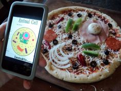 someone is holding up their cell phone to take a picture of a pizza