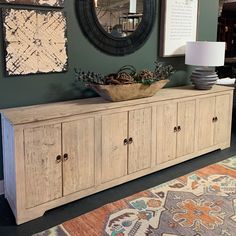 a large wooden cabinet sitting in front of a wall with pictures hanging on it's sides