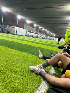 two soccer players sitting on the ground with their legs crossed