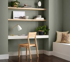 a room with green walls and wooden shelves on either side of the window sill