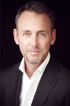 a man in a black suit and white shirt