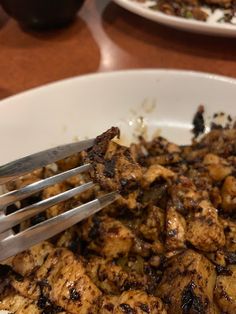 a white bowl filled with food and a fork sticking out of the top of it