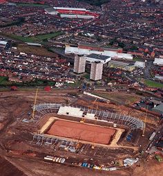 an aerial view of a stadium being built in the middle of a large city with lots of buildings around it