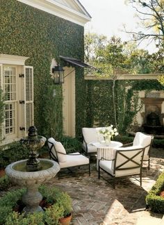 an outdoor dining area with chairs, table and fountain