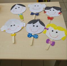 children's handmade paper cutouts on wooden sticks sitting on top of a table