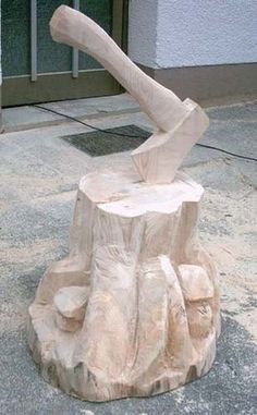 a sculpture of a person on top of a tree stump in front of a building