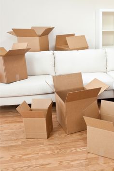 several open boxes sitting on the floor in front of a couch