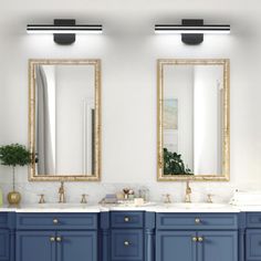 two sinks and mirrors in a bathroom with blue cabinets, white walls and gold trim