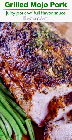 a piece of meat and green beans on a cutting board