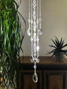 a chandelier hanging from the ceiling in front of a potted plant on a table