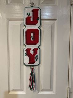 a cross stitch door hanger with the word joy on it