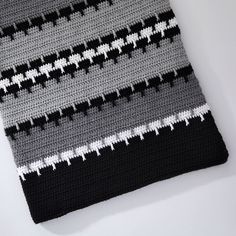 a crocheted black and white striped tie laying on top of a table