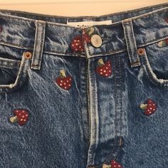 a pair of blue jeans with strawberries on them