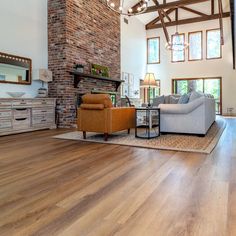 a large living room with wood floors and exposed ceilings