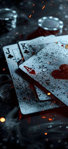 three playing cards with hearts on them are floating in the water and surrounded by fire