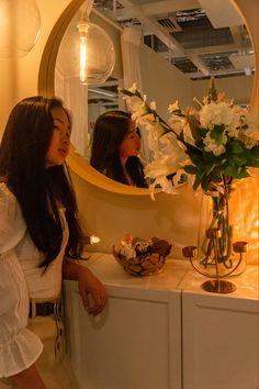 two women standing in front of a mirror