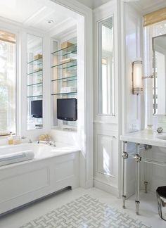 a bathroom with a tub, sink and large mirror on the wall next to it