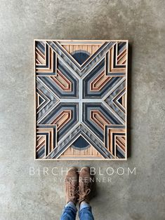 a person standing in front of a wooden art piece