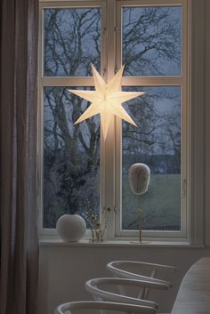 a lighted star sitting on top of a window sill