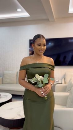 a woman in a green dress holding a bouquet