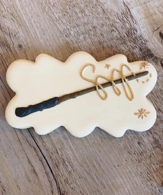 a cookie shaped like an arrow with writing on it sitting on top of a wooden table