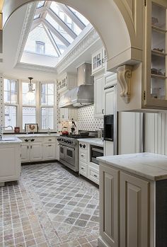 a kitchen with an arched ceiling and white cabinets