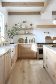 Bright modern kitchen with wooden cabinets, floating shelves, and stainless steel appliances. Transitional Boho Kitchen, House Inspo Interior Design Kitchen, Small Wooden Kitchen Ideas, Kitchen Projects Plan, Natural Interior Design Apartment, Organic Modern Style Kitchen, Light Wood Home Interior, Modern Clean Kitchen Design, Organic Modern Inspiration