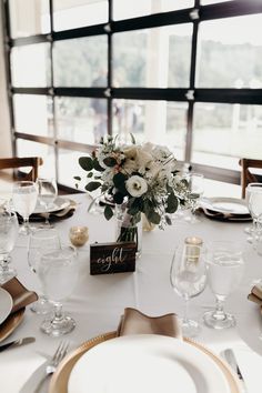 a table set with white and gold place settings